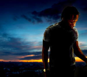 Photo of Edward Wiggins standing in front of a faded cloud skyline at sunset  